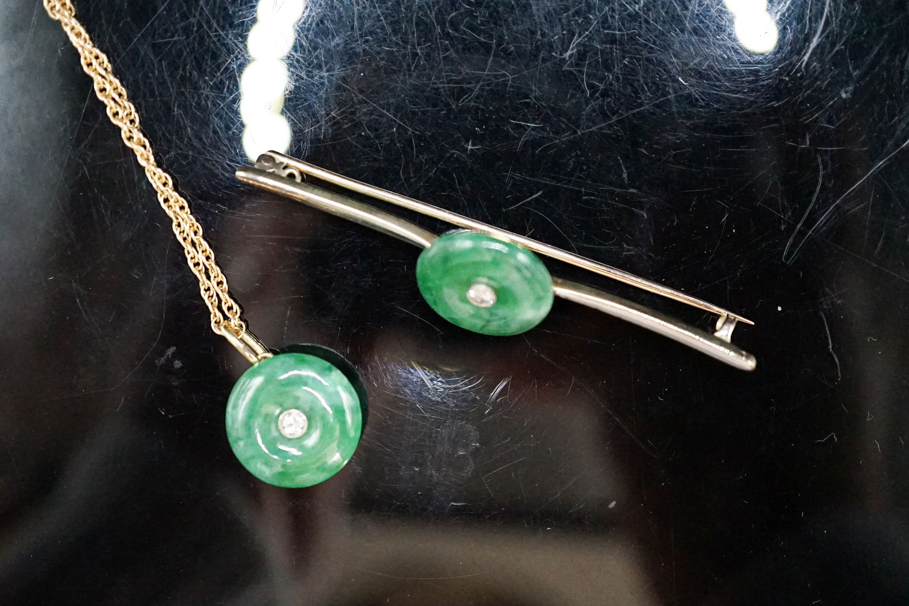 A yellow metal mounted jade and diamond set circular pendant, 14mm, on a 585 rope twist chain and a similar jade and diamond set bar brooch, 58mm, gross weight 12.8 grams